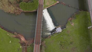 Drone aerial view of hydroelectric dam and fish passage on river in English countryside springtime video