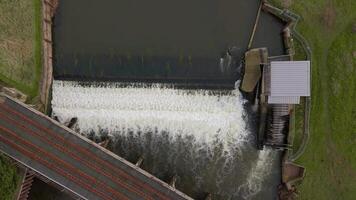 Spring aerial view of river weir and hydro power plant with fish pass in rural England video