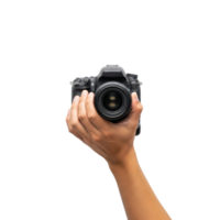 A persons hand holds a black digital singlelens reflex camera with a lens facing png