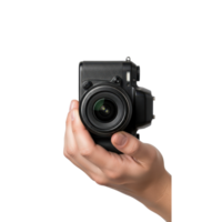 A persons hand is holding a black digital camera with a lens in a studio setting png