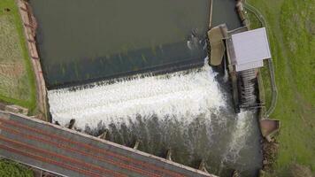 Aerial cinematic view of hydroelectric river structure with fish passage in rural England spring video
