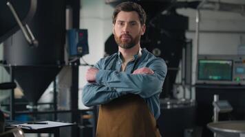 Caucasian man thinking writing document barista technologist small business owner coffee roasting factory thoughtful male write notes check manufacture equipment looking at camera posing crossed hands video