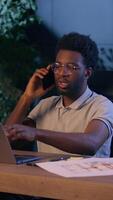 African American architect business man designer businessman in office talk mobile phone night evening online work laptop ethnic guy engineer employee overtime consultation call discuss design project video