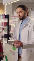Pharmacy professional assisting customer medical help doctor pharmacist advice recommend medicine pills drugs vitamins health care prescription African Caucasian multiracial men clapping hands deal video