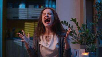 Irritated angry stressed woman Caucasian girl at home night screaming yelling shouting furious mad female crazy annoyed scream shout holding head anger madness stress negative emotions crisis problem video