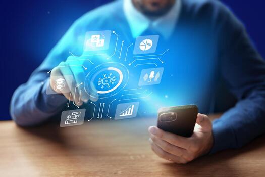 Man using smartphone with holographic technology display in modern workspace at night photo