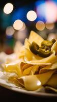 Cheesy Tortilla Chips Topped with Sliced Jalapenos in Soft Light. photo