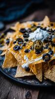 Delicious Loaded Nachos With Cheese Olives and Sour Cream. photo