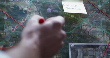 A person is pointing to a map on a sticky note photo