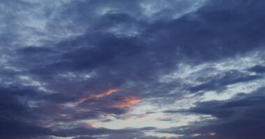A sunset over a field with a few clouds photo