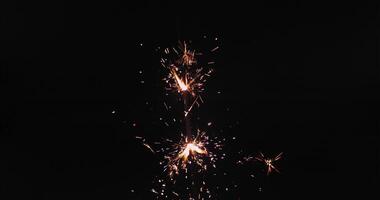A sparkler is lit up in the dark photo