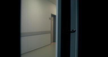 A hallway with a door open and a light on photo