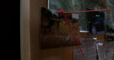A red string attached to a bulletin board photo