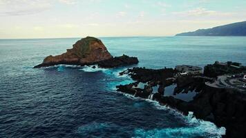 A view of the ocean from above with a lighthouse in the distance photo