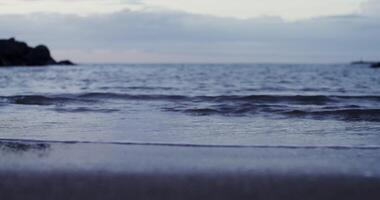 A person standing on a beach with a surfboard photo