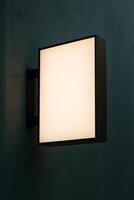 Wall Light Fixture Illuminating a Textured Interior Wall for Logo Mockup 2 photo