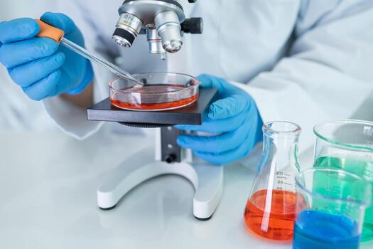 Scientist holding erlenmeyer flask, conical flask glassware with red color liquid solution in science chemistry photo