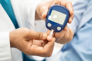 Doctor check diabetes from finger blood sugar level with finger photo