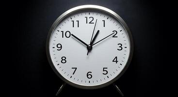 A clock is shown on a black background photo