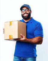 Man with beard and glasses wearing a blue shirt and cap holding a cardboard box smiling photo