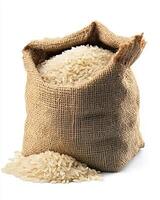 A close up shot of a burlap sack filled with white rice spilling onto a white background photo