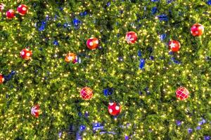 A large tree with many christmas balls hanging from it photo