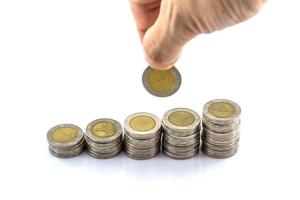Hand holding a stack of coins with a coin in the middle photo