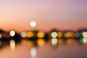 Blurred bokeh light background of the city at sunset photo