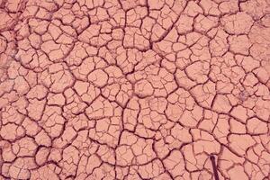 A close up of a cracked surface with a pink color photo