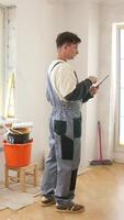 Vertical painter using digital tablet during home renovation project video