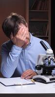 vertical Tired scientist covering face with hands in laboratory video
