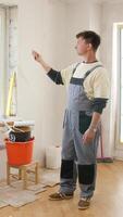 A man in overalls standing in a room with a bucket and paint video