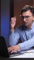 vertical Shocked scientist looking at laptop screen in laboratory at night video