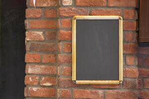 Vintage chalkboard mounted on a rustic brick wall photo