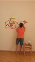 vertical Boy painting colorful graph on wall in renovated room video