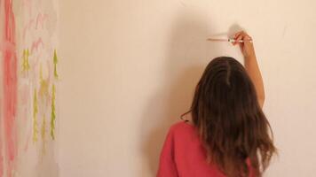 A girl is painting on the wall with a brush video