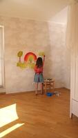 A little girl painting on a wall in a room video