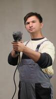 A man in overalls holding a drill video
