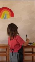 A child painting a rainbow on a wall video