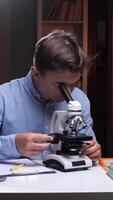 vertical Scientist working with microscope doing research in laboratory at night video