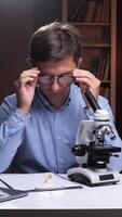 vertical Tired scientist rubbing eyes while working late at night in laboratory video