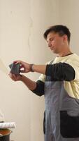 Vertical concerned construction worker checking an empty wallet during a renovation break, revealing financial struggles in home improvement video