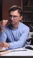 vertical Scientist examining microscope slide in laboratory setting video