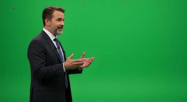 A man in a suit and tie is standing in front of a green screen photo