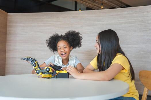 Cheerful Young Girls Engaged in Robotics and STEM Learning, Diverse Kids Building a Robot Arm in a Science Workshop, Two Girls Exploring Technology and Innovation photo
