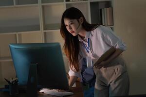 Remote Work. Young professional woman focused on computer screen in modern office. photo