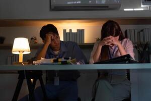 Stressed colleagues facing challenges in a dimly lit office photo