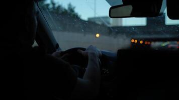 Man holding steering wheel while driving car on highway at dusk with dirty windshield video