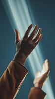 Hands raised in prayer reaching toward divine light beams. Spiritual worship, faith and hope concept with dramatic lighting. Religious devotion and meditation moment. photo