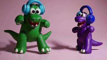 Colorful plasticine dinosaurs wearing headphones, dancing and grooving together with vibrant energy against pink background, expressing musical joy video